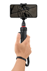 JOBY tripod in handgrip mode being held by a hand with thumb on remote shutter button and strap around wrist.