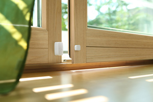 Eve Wireless Contact Sensors, mounted near the bottom of a door and the door casing, in the open position.