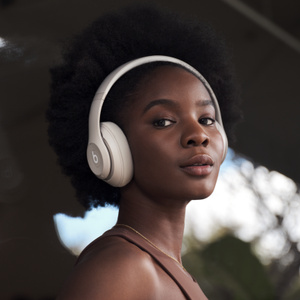 Side view of Beats Studio Pro Wireless Headphones in Sandstone, showing distinctive Beats logo.