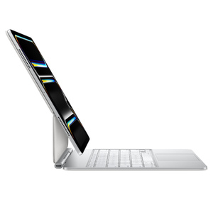 Parte lateral exterior de un iPad Pro con Magic Keyboard blanco, en posición horizontal e inclinado hacia atrás, con un puerto de carga cerca del pliegue y diseño flotante