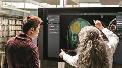 A man and a woman looking at a scan report on a screen