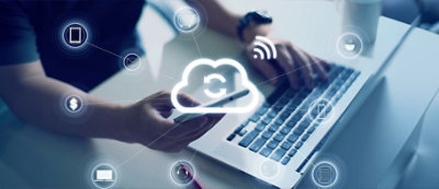 A person using a smartphone and a laptop, with icons representing cloud computing and various services like email, internet