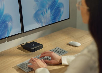 A woman using a keyboard on a desk.