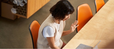 A woman in a white sweater sitting at a table.