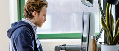 A person sitting and working on his desktop.